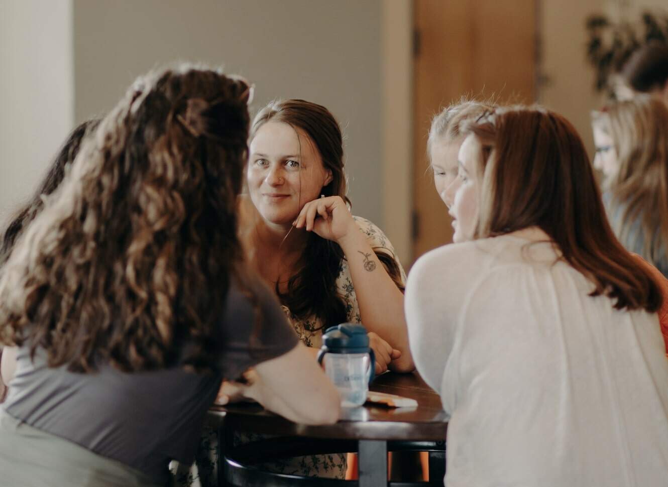 Women sit around a table talking at Emmaus Road Church in Bozeman, MT